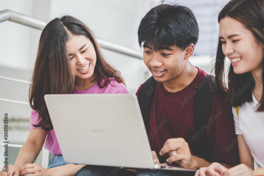 Education concept - Happy young university students enjoy using laptops on campus. Education concept - Happy young university students enjoy using laptops on campus.