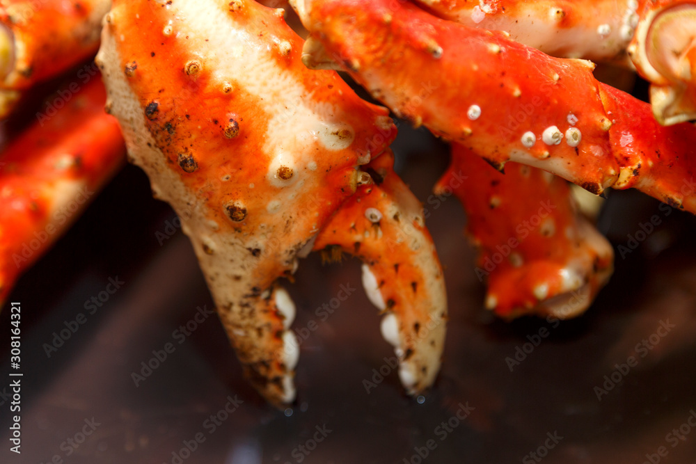 Claws baked Kamchatka crab whole on a black plate. Claws baked Kamchatka crab whole on a black plate.