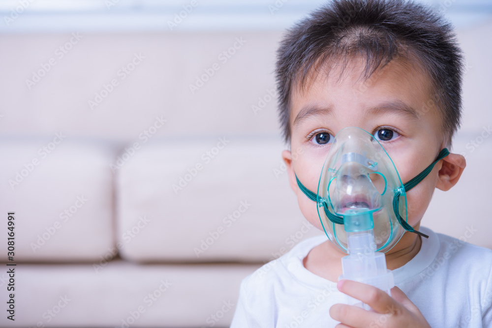 Closeup asian face little children boy using steam inhaler nebulizer mask inhalation