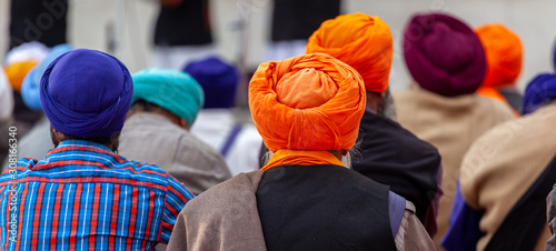 Schilderij op canvas Panoramic of Sikh people from the back with their colory turban at the golden te