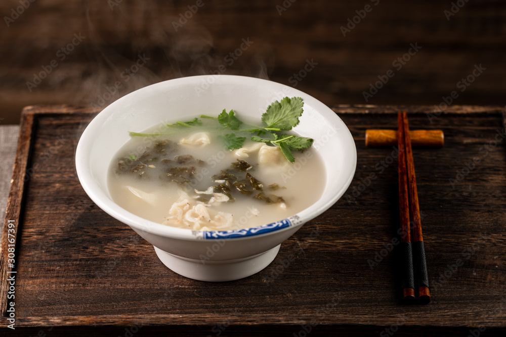 Shrimp wonton with braised pork in soup on wooden table / Select focus image... Shrimp wonton with braised pork in soup on wooden table / Select focus image...