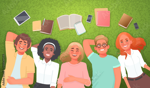 Concept of student life and friendship. Happy friends boys and girls lying on the grass with books and gadgets. Study