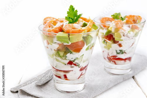 Salad with shrimp and avocado in two glasses on table
