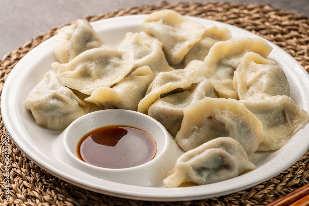 Close up fresh boiled dumplings with hot steams on wood plate. Chinese food on rustic old vintage wooden background. Close up fresh boiled dumplings with hot steams on wood plate. Chinese food on rustic old vintage wooden background.