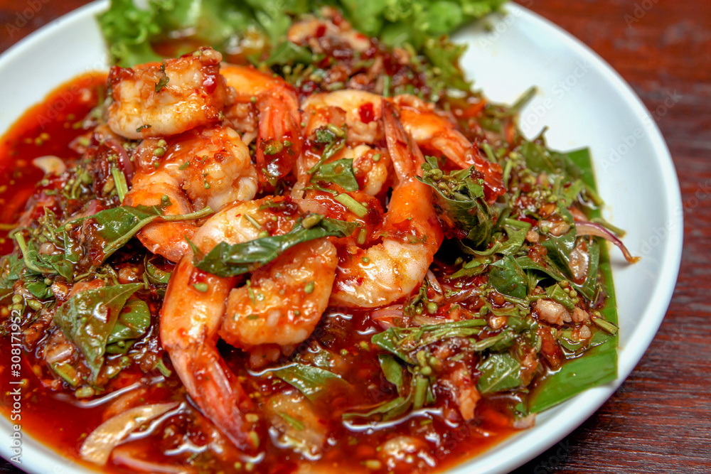 Spicy Neem Tree flower with prawns salad on a white plate on a wooden table Spicy Neem Tree flower with prawns salad on a white plate on a wooden table