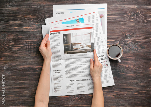 Woman reading newspapers at...
