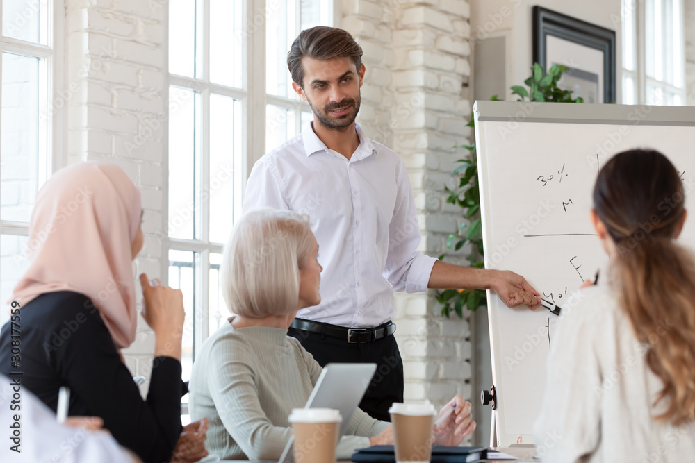 Fototapeta premium Focused mixed race colleagues listening to professional male speaker.