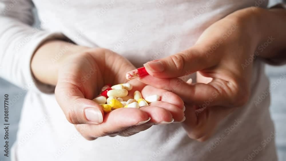A woman holds vitamins and tablets in her hands. He fumbles with the pills. Food supplements vitamins and tablets of different types. A woman holds vitamins and tablets in her hands. He fumbles with the pills. Food supplements vitamins and tablets of different types.