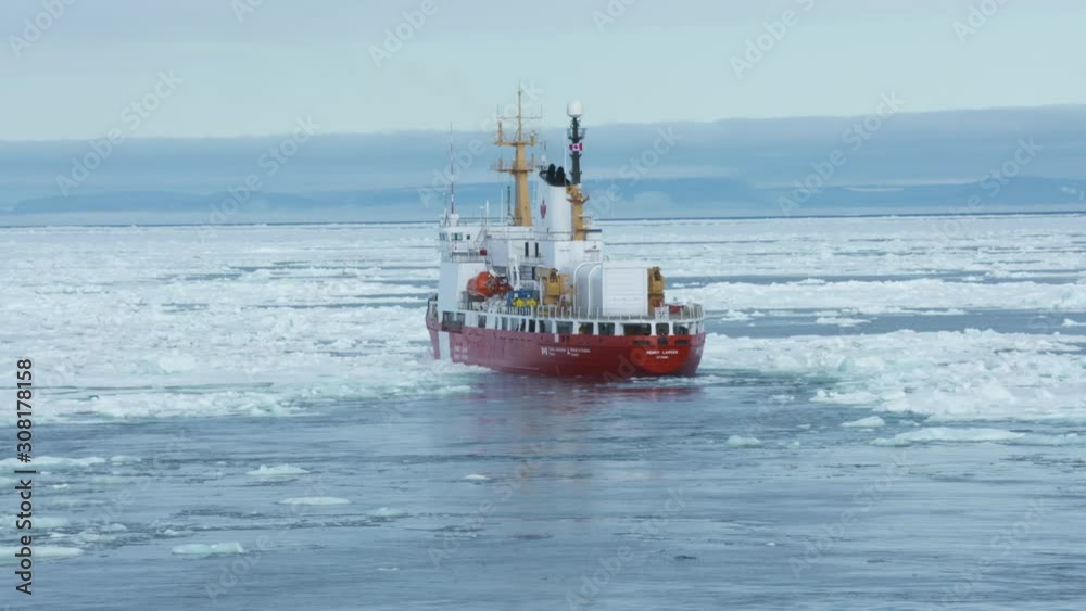 Handheld, medium wide shot of a steam ship slowly trudging through thick ice. Handheld, medium wide shot of a steam ship slowly trudging through thick ice.