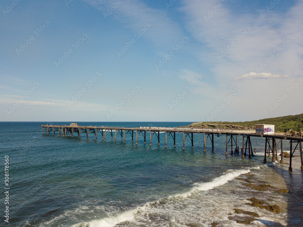 View of a jetty on the coastline during the day.