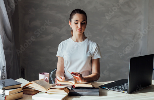 girl is preparing for the exam reading book works at the computer photo