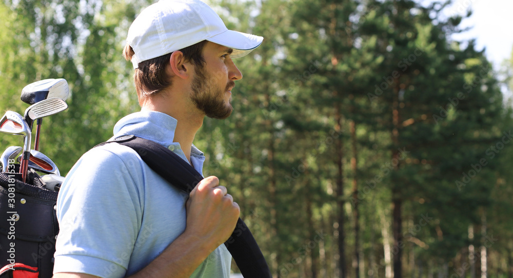 Obraz premium Golf player walking and carrying bag on course during summer game golfing.