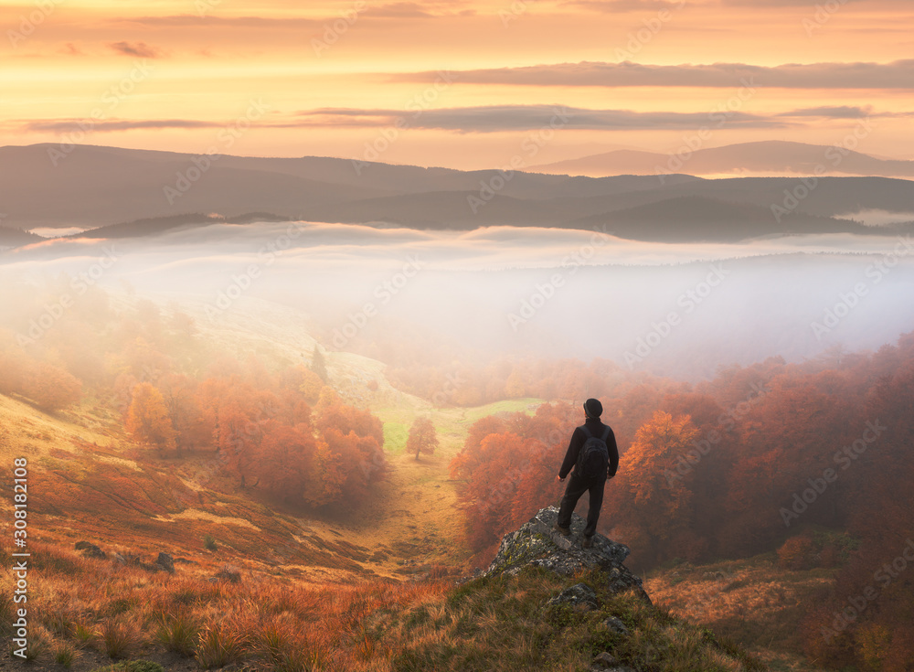 Man stands on background of autumn landscape