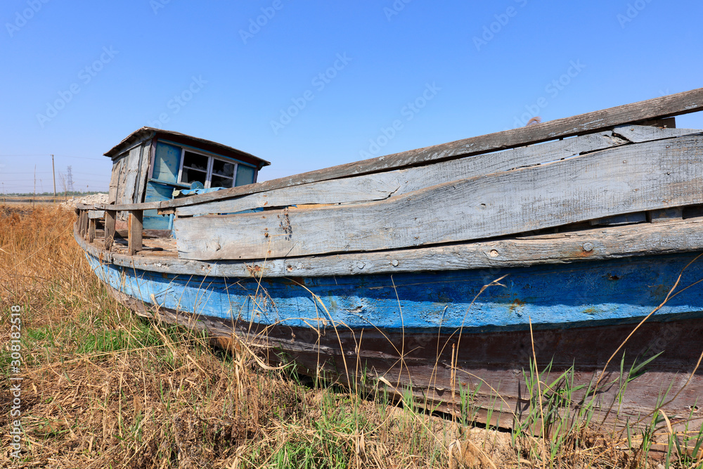 The broken wooden boat is on land