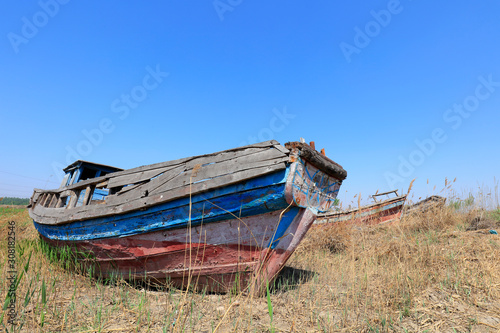 The broken wooden boat is on land