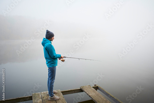 Woman standing on pier with fishing rod