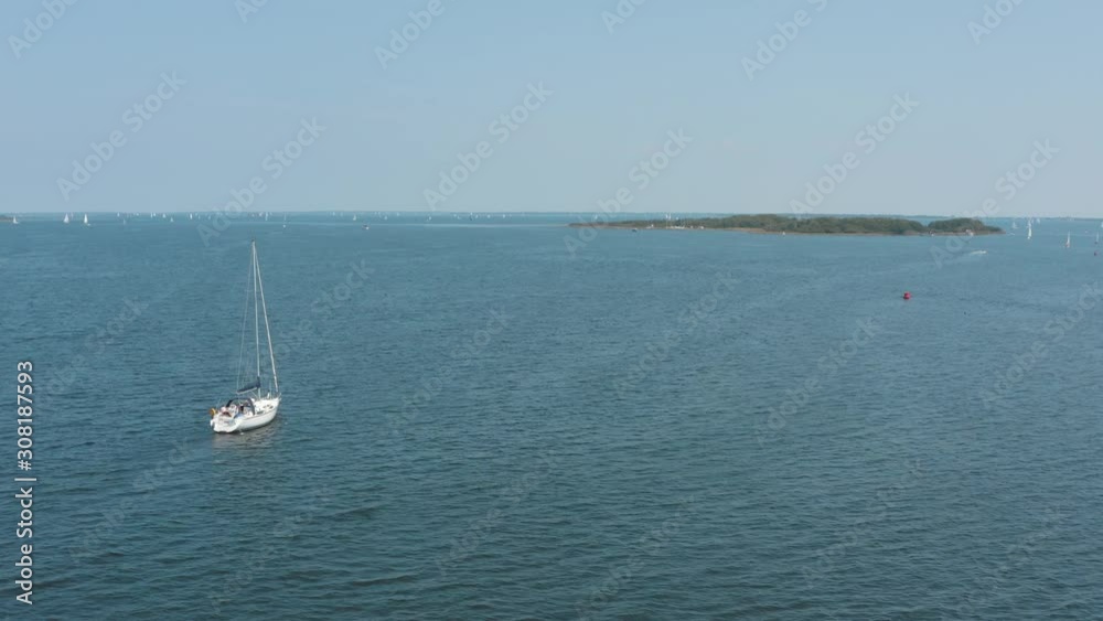 Cinematic drone / aerial shot of a boat sailing on the wavy ocean with a island and other surfer in the background on a sunny day, 25p Cinematic drone / aerial shot of a boat sailing on the wavy ocean with a island and other surfer in the background on a sunny day, 25p