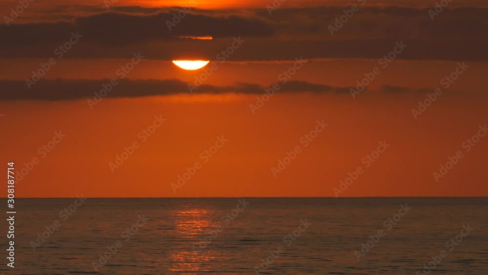 Orange ocean sunrise over calm sea reflecting sunlight on water Orange ocean sunrise over calm sea reflecting sunlight on water
