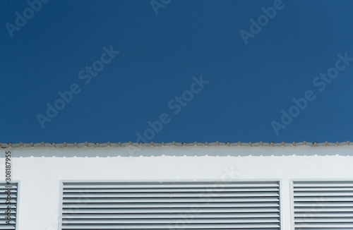simple part of white building with metal roof with blue sky minimalism architecture background