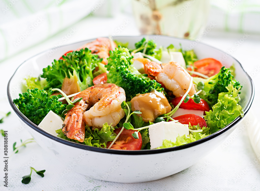 Delicious fresh salad with shrimps / prawns, broccoli, feta cheese, tomatoes, lettuce and peanut dressing. Diet menu. Top view Delicious fresh salad with shrimps / prawns, broccoli, feta cheese, tomatoes, lettuce and peanut dressing. Diet menu. Top view
