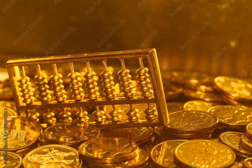 A gold abacus was placed on the background of the pile of COINS A gold abacus was placed on the background of the pile of COINS