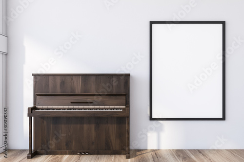 Wooden piano in white room with poster photo