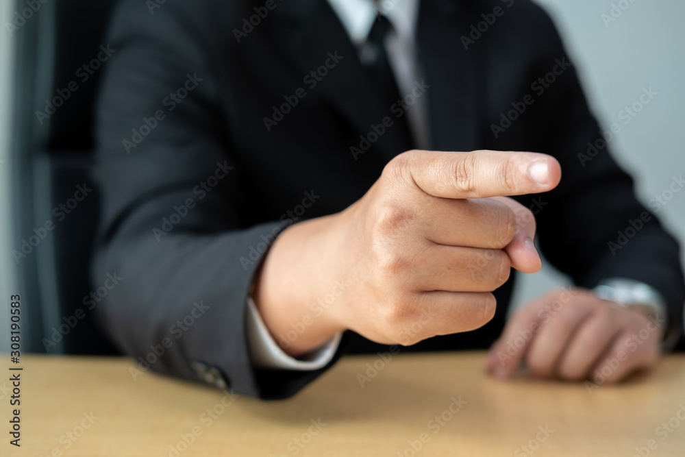 Business man pointing finger at you at desk Business man pointing finger at you at desk