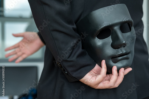 Photo A business man with a black mask covering the insincerity of doing business together
