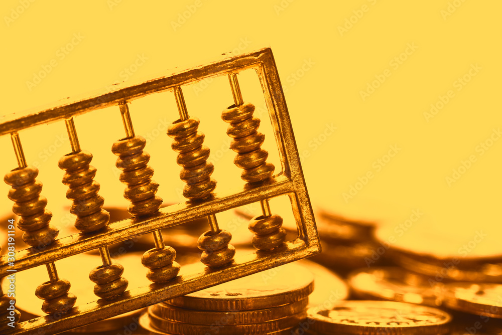 A gold abacus was placed on the background of the pile of COINS A gold abacus was placed on the background of the pile of COINS