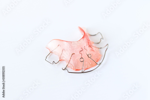 Pink retainers on white background. Retainers are important after braces. photo