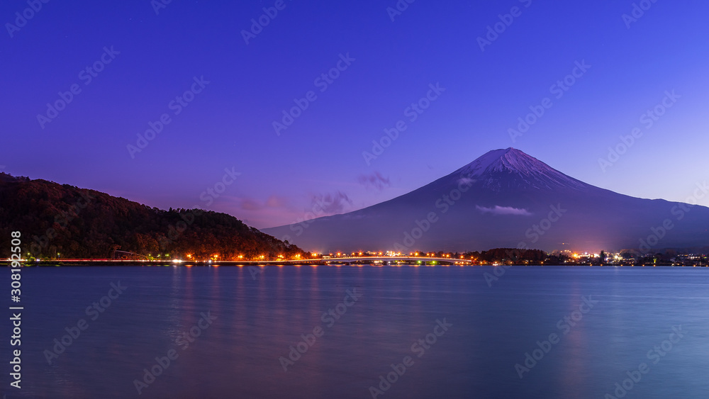 Landscape of mount fuji and city lighting at lake kawaguchiko in early night.