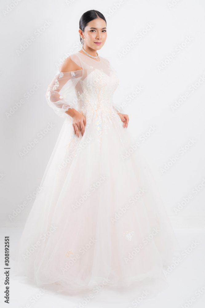 Beautiful bride portrait wearing a white wedding dress with a luxury at studio shoot isolated on white background. Beautiful bride portrait wearing a white wedding dress with a luxury at studio shoot isolated on white background.