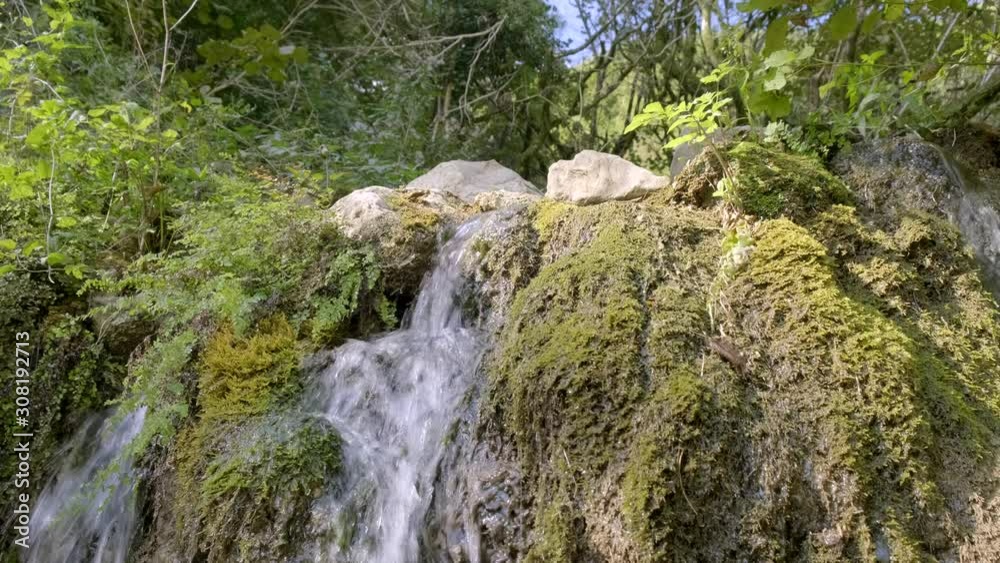 stream of water flowing from mountain in autumn forest. Mountain waterfall in forest on sunny day. stream of water flowing from mountain in autumn forest. Mountain waterfall in forest on sunny day.