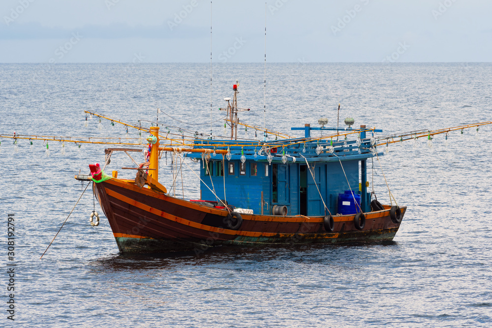 Fishing boats are overwhelmingly in the midst of the sea on a beautiful blue sky. Fishing boats are overwhelmingly in the midst of the sea on a beautiful blue sky.