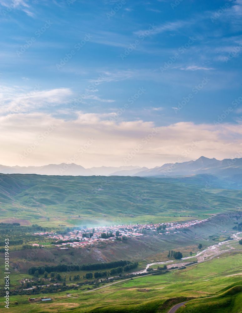 Peaceful village on green hillside with blue morning sky Peaceful village on green hillside with blue morning sky