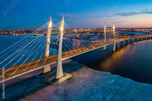 Saint Petersburg. Russia. Bridges Of St. Petersburg. Cable-stayed bridge over the Neva river. Movement of cars on the Obukhov bridge. Panorama of evening St. Petersburg. Gulf of Finland with ice. © Grispb