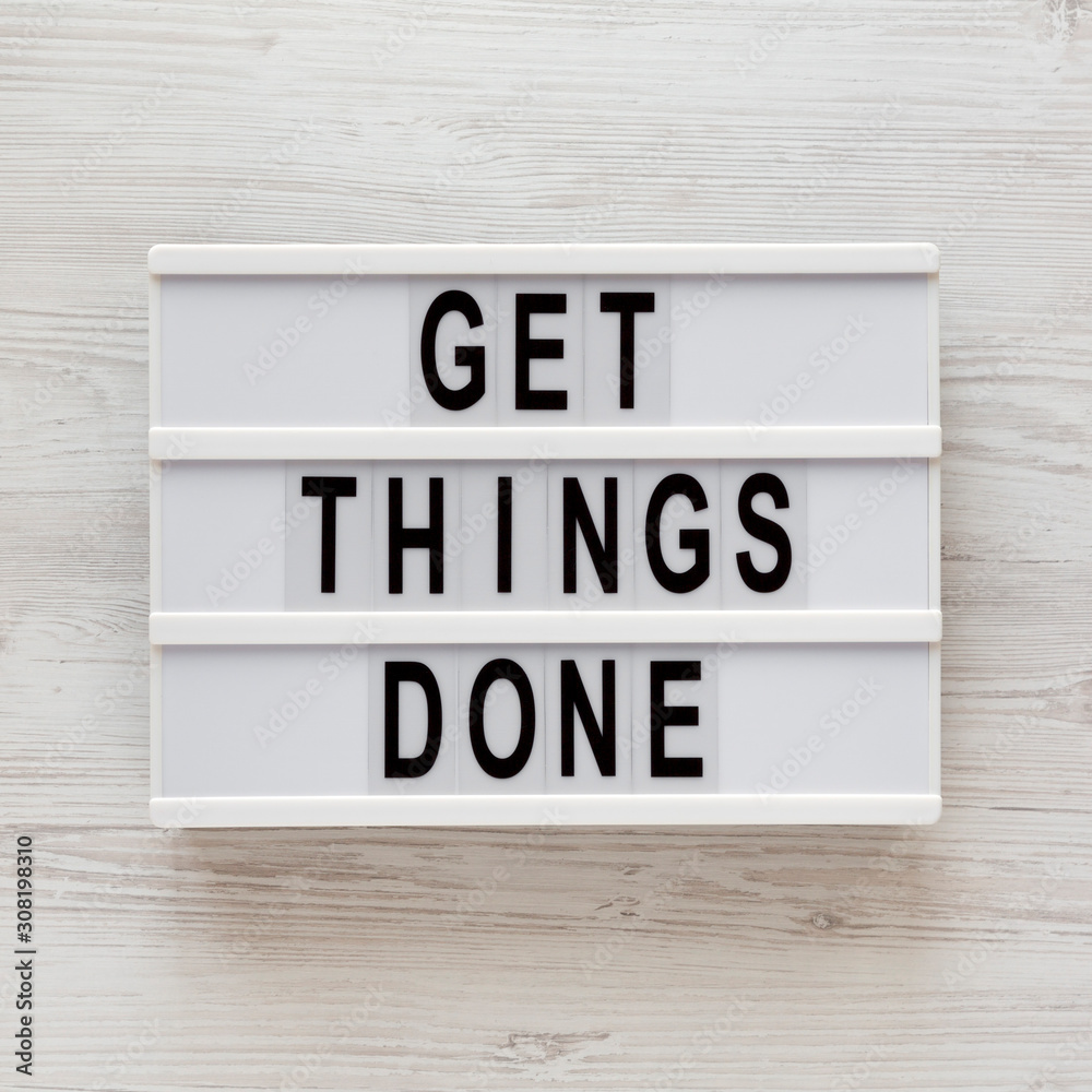 'Get things done' words on a modern board on a white wooden background, top view. Overhead, from above, flat lay. Close-up. 'Get things done' words on a modern board on a white wooden background, top view. Overhead, from above, flat lay. Close-up.