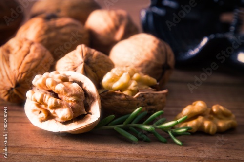 open walnuts and nutcracker on wood