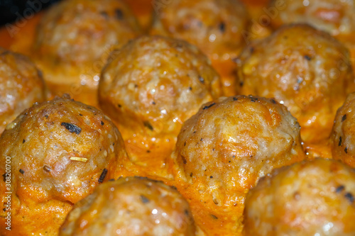 Delicious baked meatballs in the oven. Cooked in a creamy sauce. Selective focus.