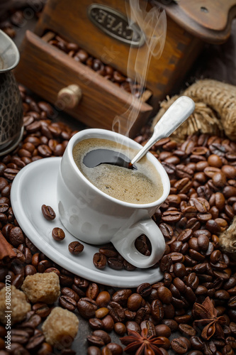 Coffee in a cup on a background of coffee beans, on an old background.