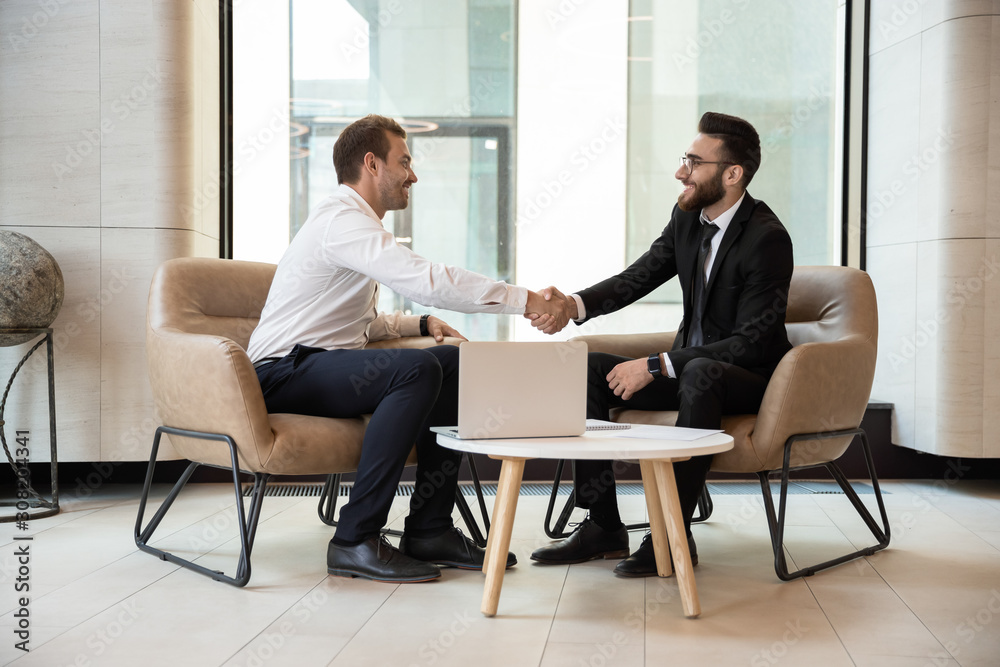 Multiracial businessmen handshake getting acquainted at meeting Multiracial businessmen handshake getting acquainted at meeting