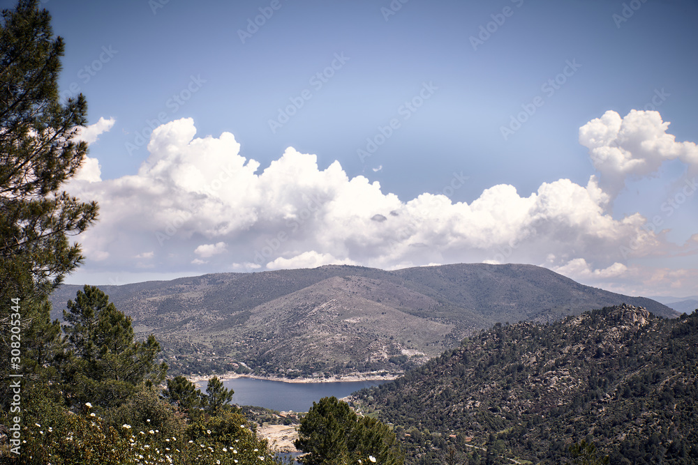 Panoramic of some mountains under a cloudy blue sky