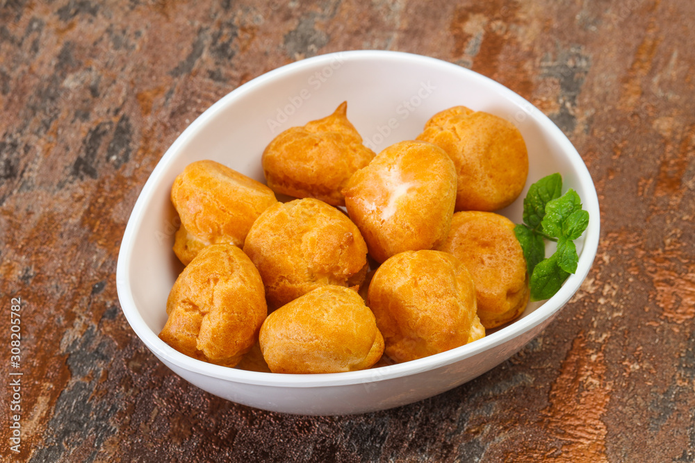 Sweet tasty profiteroles heap in the bowl