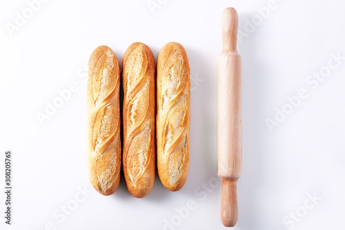 Freshly baked French baguettes on white wooden table.