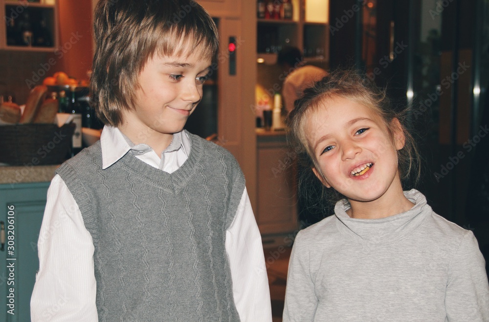 Portrait of little caucasian girl and boy in casual clothes hugging