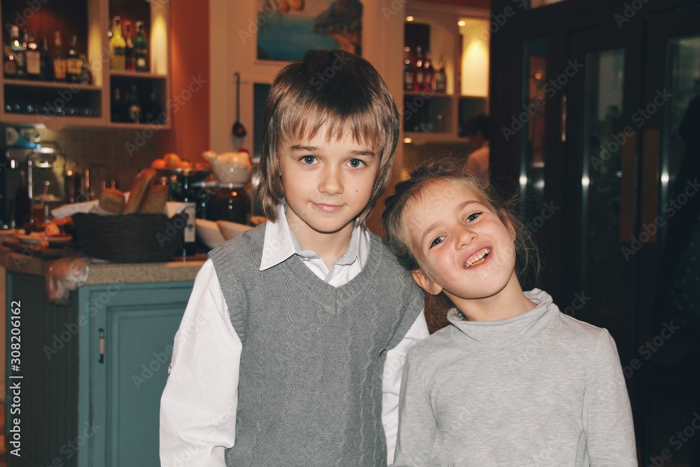 Portrait of little caucasian girl and boy in casual clothes hugging