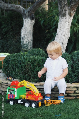 Obraz na płótnie Portrait of little caucasian boy playing with toys in garden w salonie