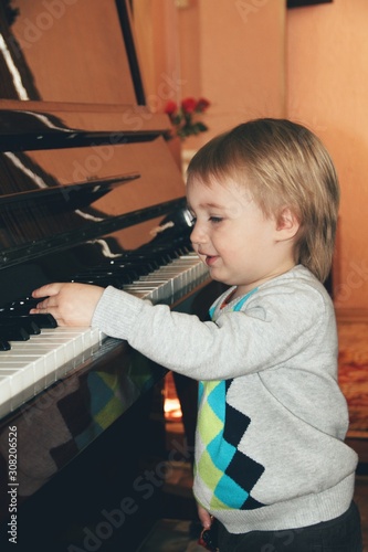 Portrait of little caucasian boy playing piano at home