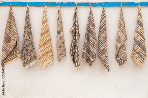 Fototapeta Naklejka Na Ścianę i Meble -  Traditional small carpets selling in streets of Tunisia. Horizontal color photography.