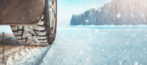 Car wheel with winter tire on snow road
